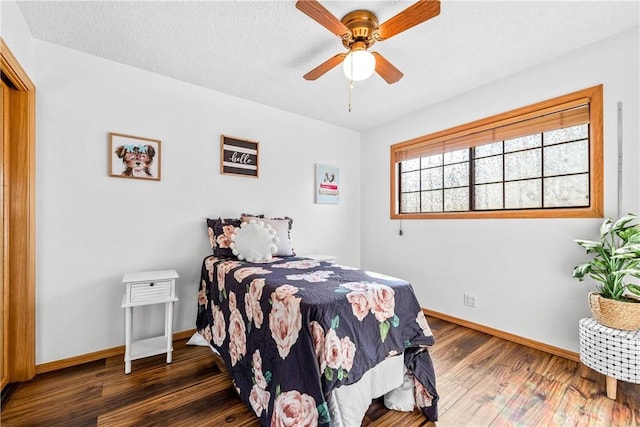 bedroom with ceiling fan, dark hardwood / wood-style flooring, and a textured ceiling