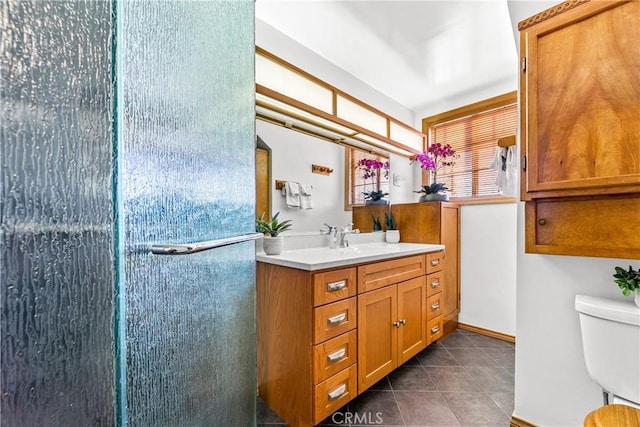 bathroom featuring tile patterned flooring, vanity, toilet, and walk in shower