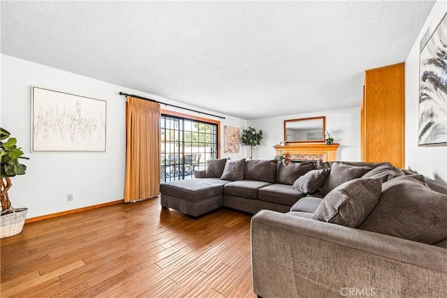 living room with a textured ceiling and light wood-type flooring