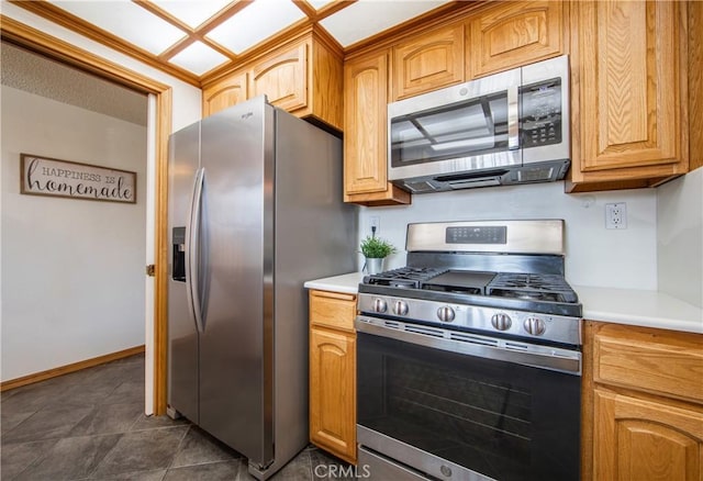 kitchen featuring stainless steel appliances and dark tile patterned floors