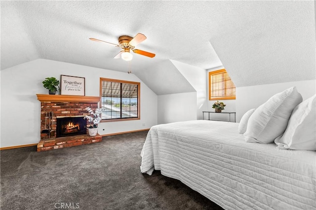 bedroom with a fireplace, lofted ceiling, ceiling fan, dark carpet, and a textured ceiling