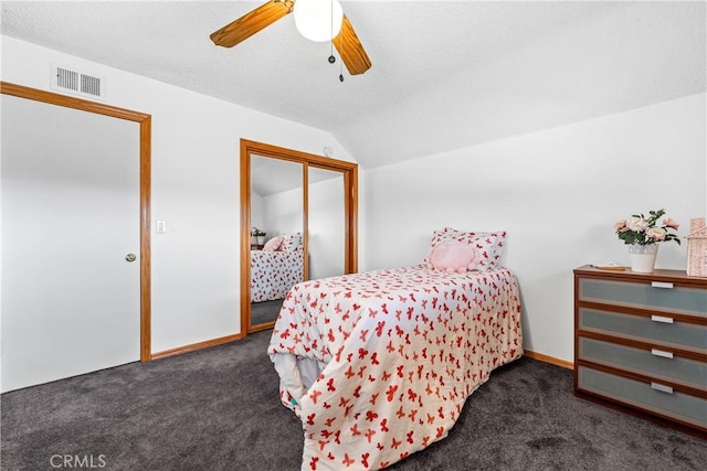 carpeted bedroom featuring a textured ceiling, vaulted ceiling, a closet, and ceiling fan