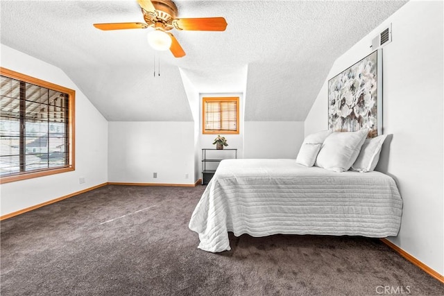 bedroom with ceiling fan, lofted ceiling, a textured ceiling, and dark colored carpet