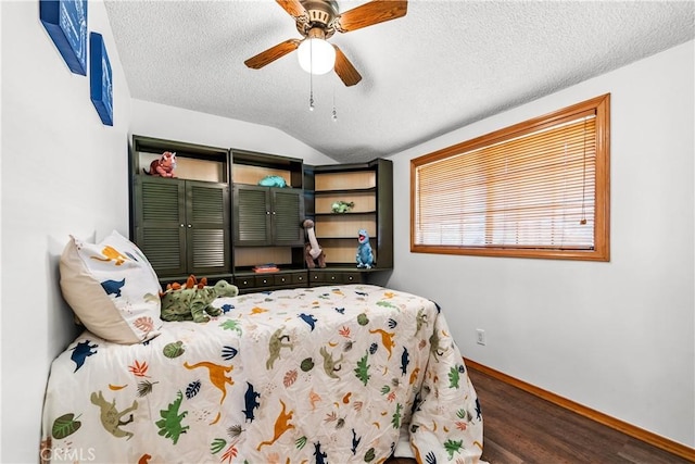 bedroom featuring vaulted ceiling, dark wood-type flooring, ceiling fan, and a textured ceiling