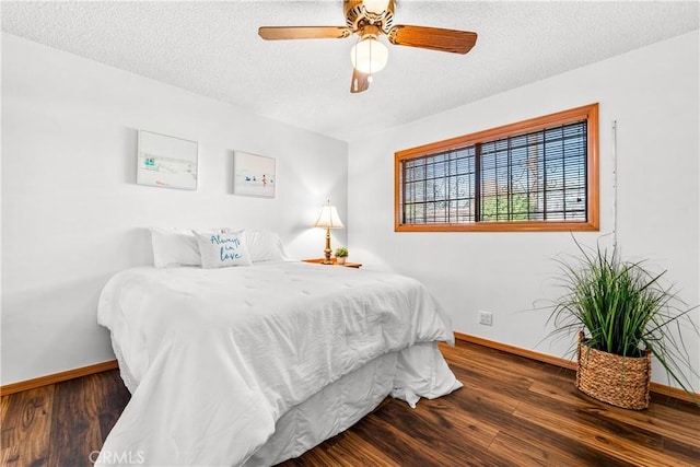 bedroom with ceiling fan, dark hardwood / wood-style floors, and a textured ceiling