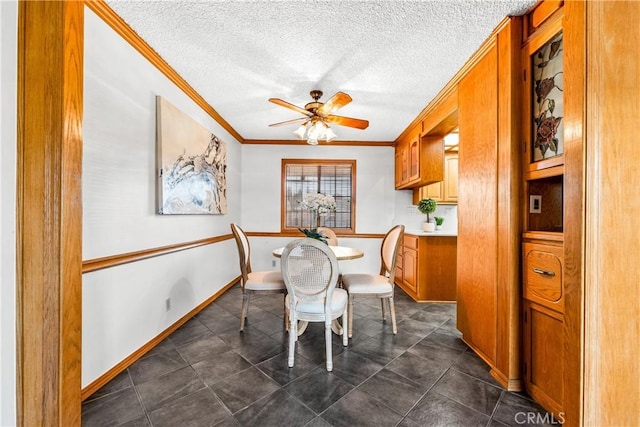 dining area featuring dark tile patterned floors, crown molding, ceiling fan, and a textured ceiling