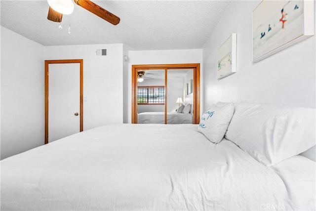 bedroom with a textured ceiling, a closet, and ceiling fan