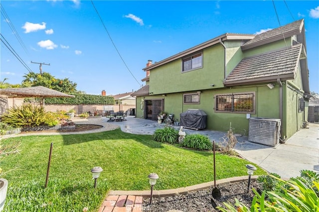 back of property with a lawn and a patio