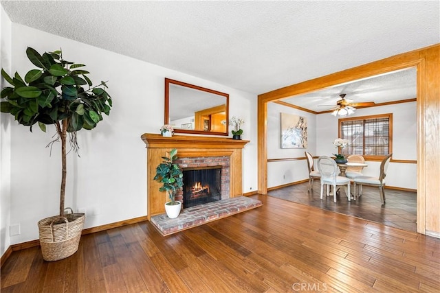 living room with hardwood / wood-style flooring, a textured ceiling, and a fireplace