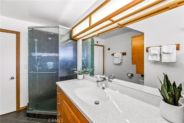 bathroom featuring tile patterned flooring, vanity, a shower with door, and toilet