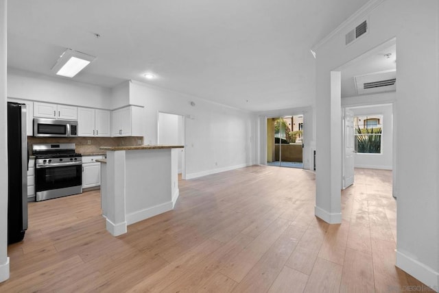 kitchen featuring light wood-type flooring, white cabinets, backsplash, and stainless steel appliances