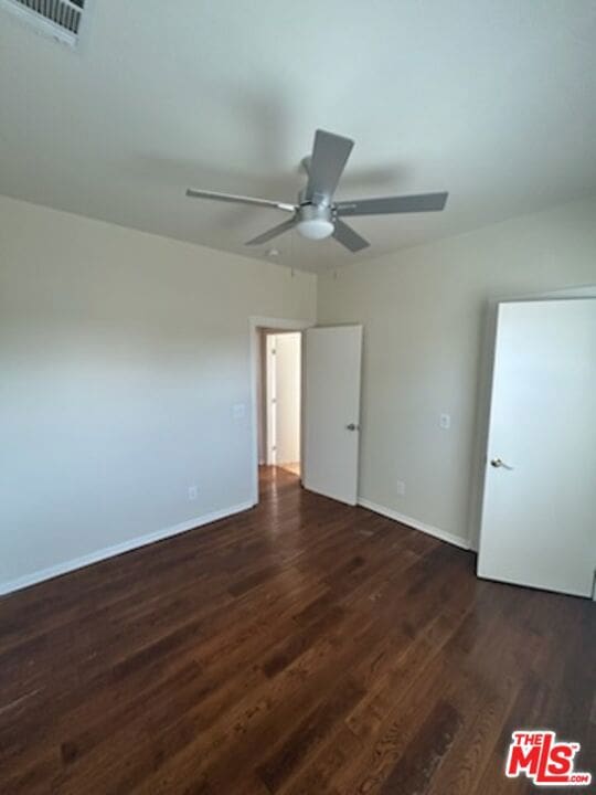 unfurnished bedroom with dark wood-type flooring and ceiling fan