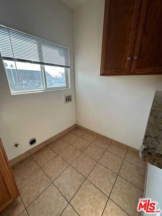 laundry room featuring light tile patterned floors, washer hookup, and cabinets