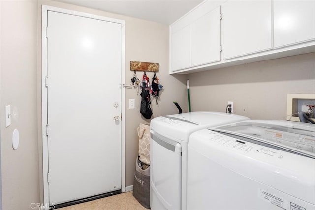 laundry room with washer and dryer and cabinets