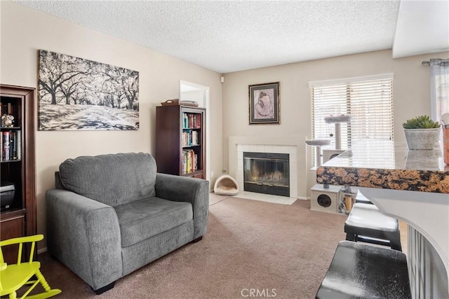 carpeted living room with a textured ceiling and a tiled fireplace