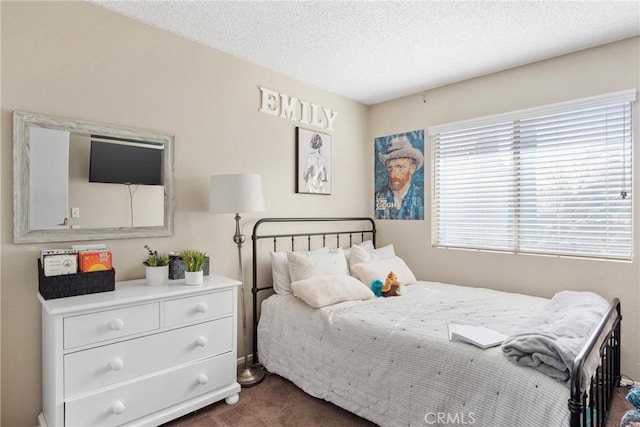 bedroom with dark carpet and a textured ceiling