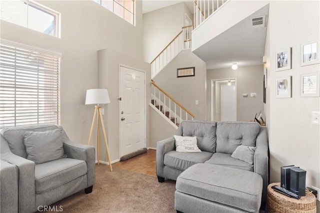 living room featuring light carpet and a towering ceiling