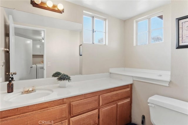 bathroom with toilet, vanity, and independent washer and dryer