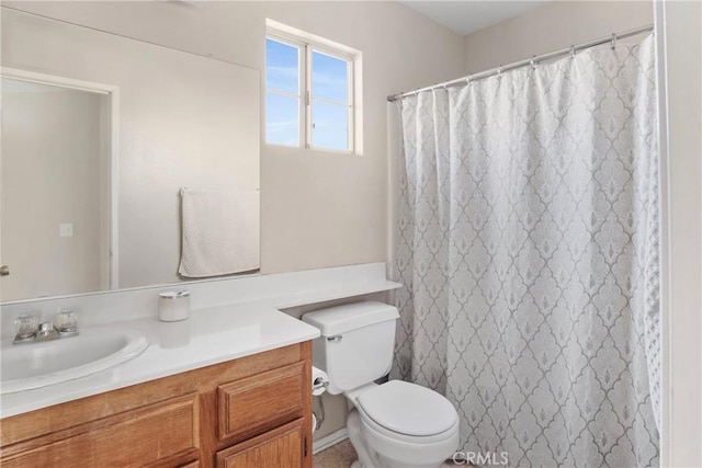 bathroom featuring toilet, a shower with shower curtain, and vanity