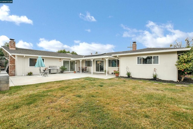 back of house featuring a yard and a patio area