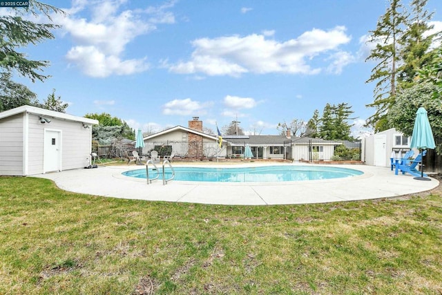 view of swimming pool with a yard, a patio area, and a shed