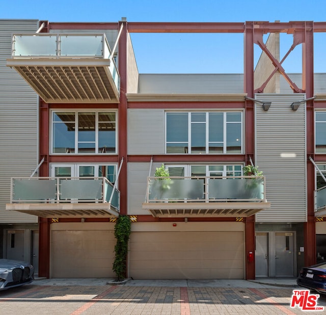 view of property with a garage and a balcony