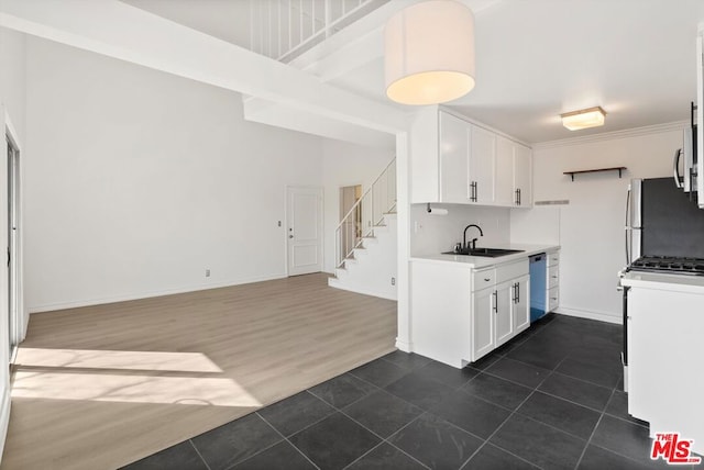 kitchen featuring white cabinets, dark tile patterned flooring, sink, and stainless steel appliances