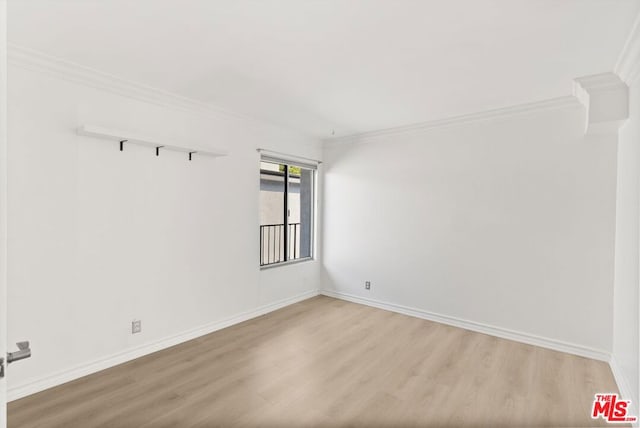 empty room with wood-type flooring and crown molding