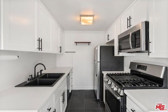 kitchen featuring white cabinets, dark tile patterned flooring, sink, and stainless steel appliances