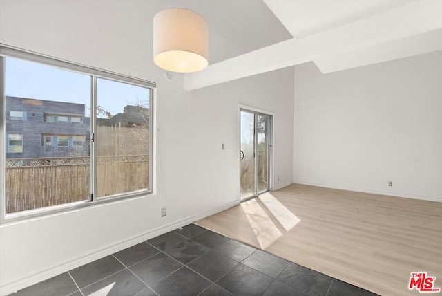 spare room featuring dark tile patterned floors