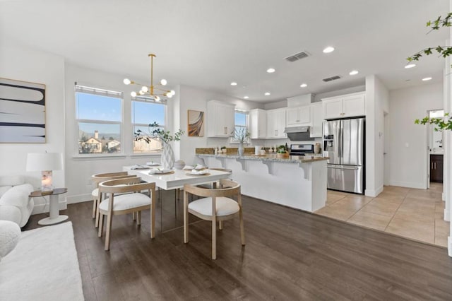 dining space featuring a chandelier and light wood-type flooring