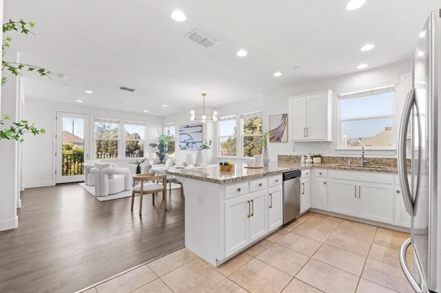 kitchen with white cabinetry, sink, kitchen peninsula, and appliances with stainless steel finishes