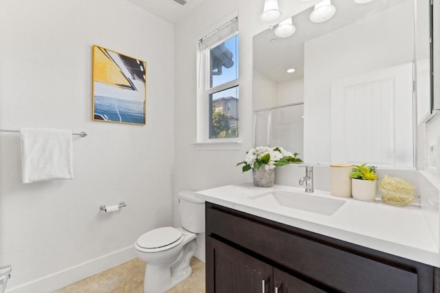 bathroom featuring vanity, tile patterned flooring, toilet, and walk in shower