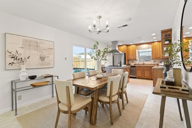 dining room featuring sink, light tile patterned floors, and an inviting chandelier