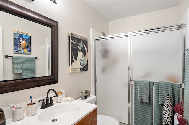 bathroom with vanity, a shower with door, and toilet