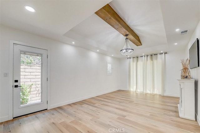 unfurnished living room featuring a chandelier, light hardwood / wood-style floors, and beamed ceiling