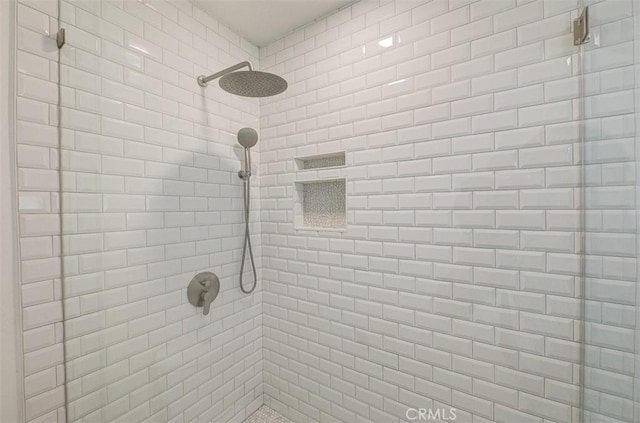 interior details featuring a tile shower