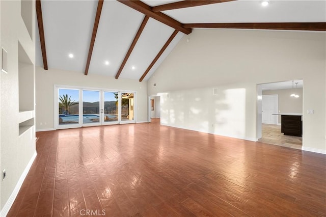 unfurnished living room with beamed ceiling, hardwood / wood-style floors, and high vaulted ceiling