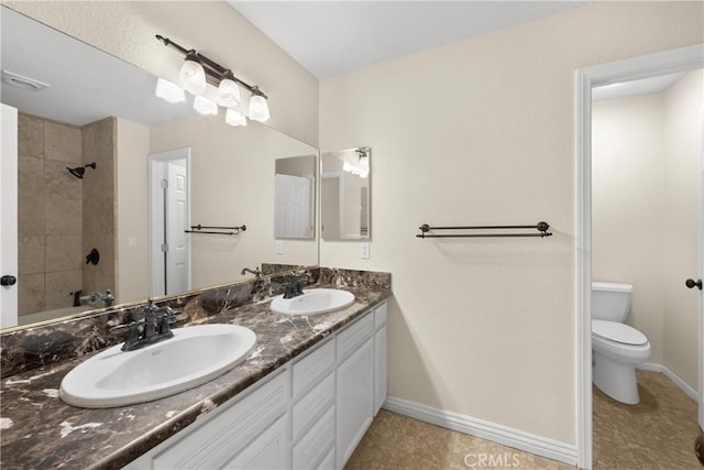 full bathroom featuring tile patterned flooring, vanity, tiled shower / bath, and toilet