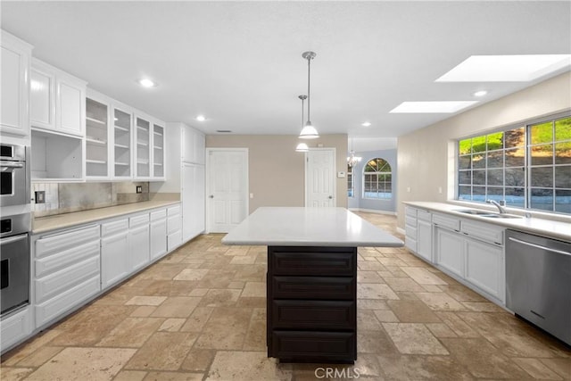 kitchen with stainless steel appliances, a center island, sink, and white cabinets