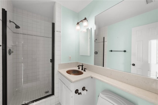 bathroom with a shower with door, vanity, and toilet