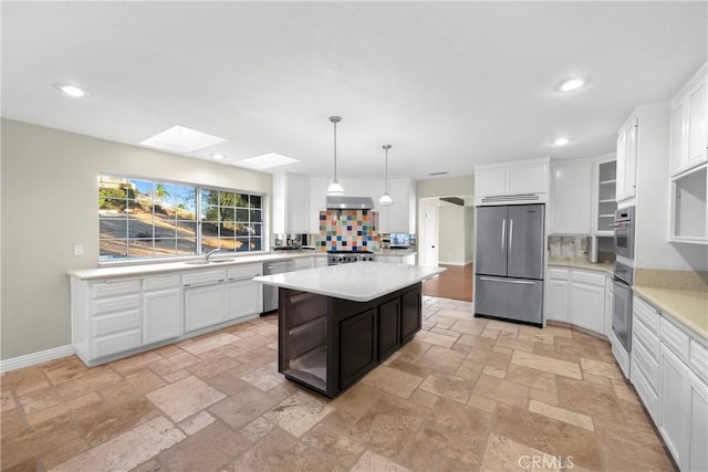 kitchen featuring white cabinetry, appliances with stainless steel finishes, sink, and decorative light fixtures