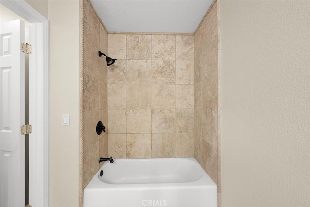 bathroom featuring tiled shower / bath