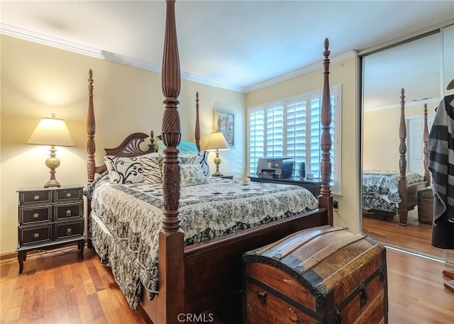 bedroom featuring a closet, ornamental molding, and wood-type flooring