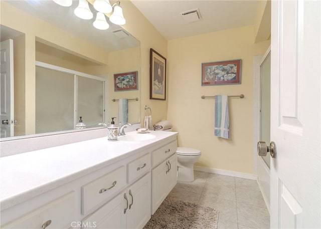 bathroom featuring tile patterned floors, a shower with door, toilet, and vanity