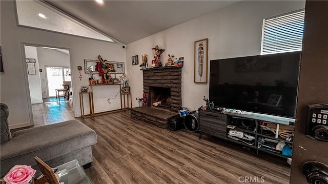 living room featuring lofted ceiling, a fireplace, and hardwood / wood-style floors