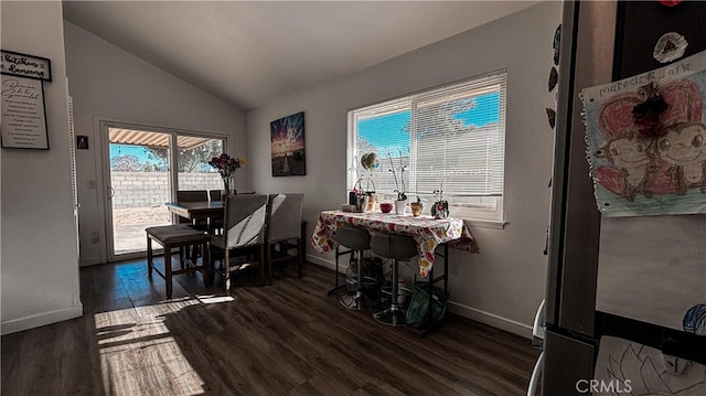 dining room with a healthy amount of sunlight, vaulted ceiling, and dark hardwood / wood-style flooring