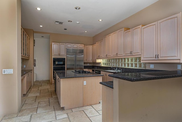 kitchen featuring dark stone counters, sink, a kitchen island, stainless steel appliances, and light brown cabinets