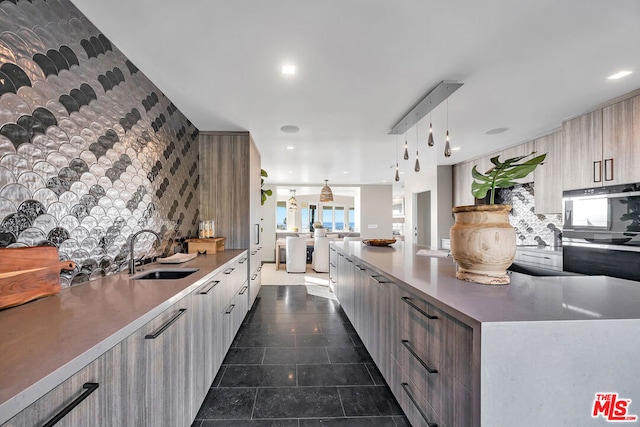 kitchen featuring decorative backsplash, sink, and pendant lighting