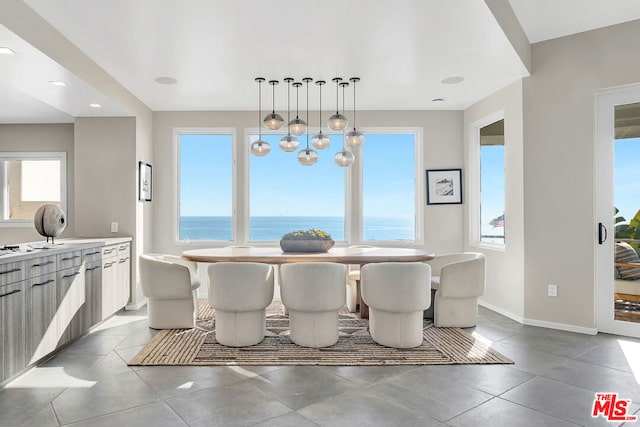 dining room with a water view, a wealth of natural light, and a chandelier